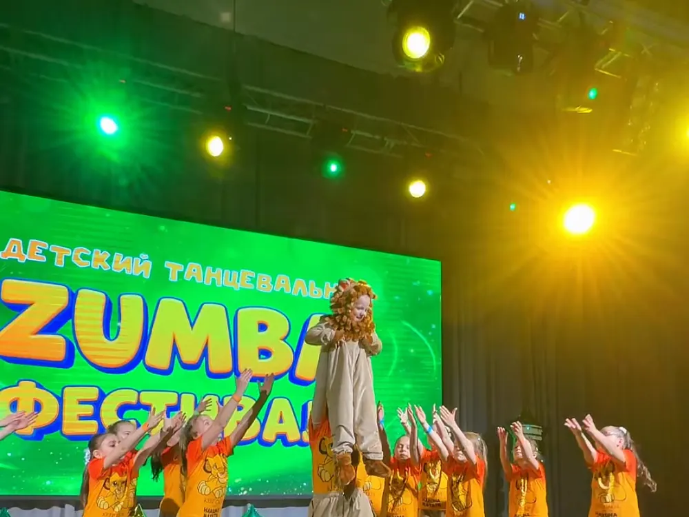 Дети выступают на сцене детского танцевального фестиваля Zumba®
